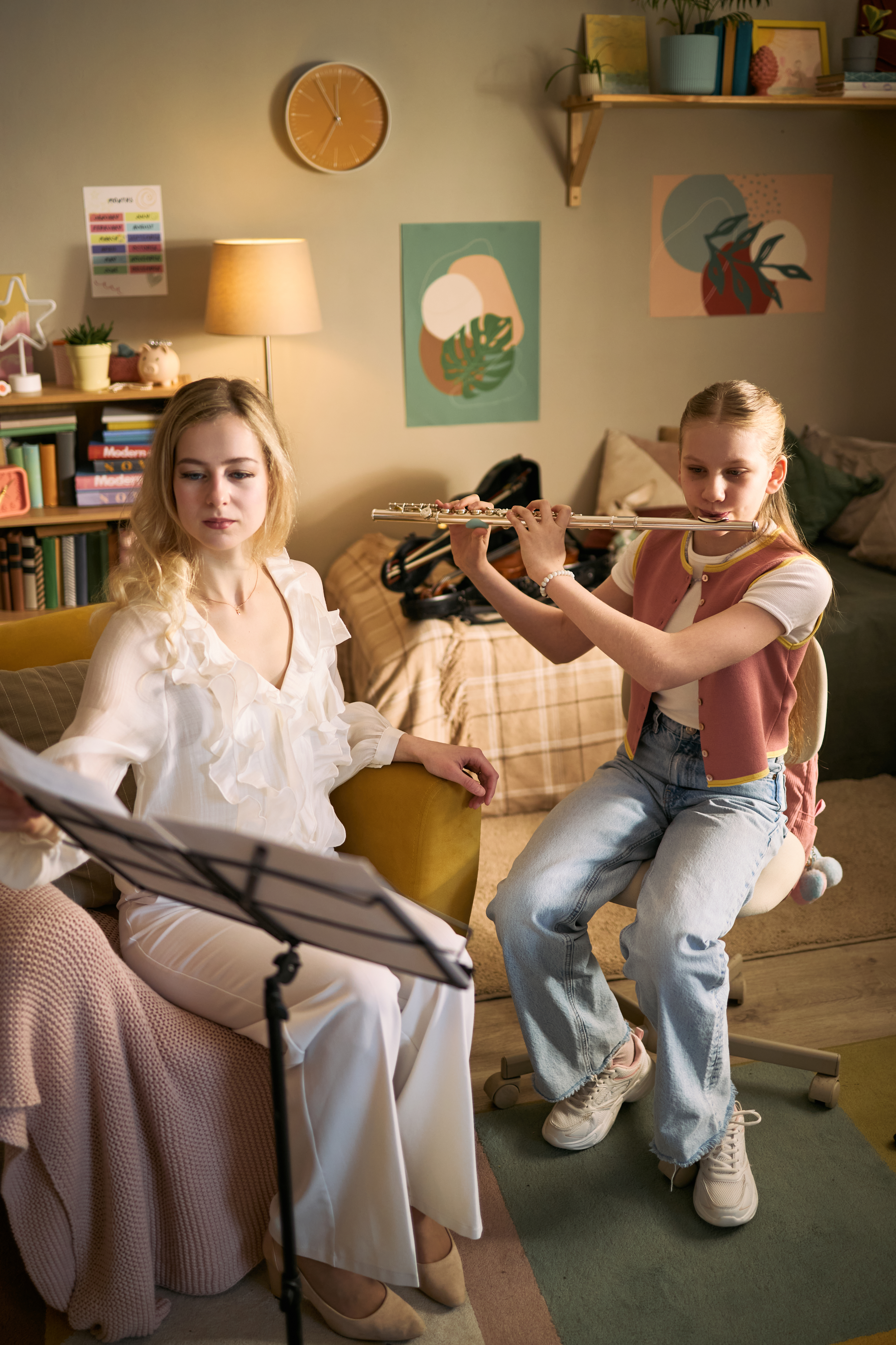 Teenage girl playing flute during music lesson with female teacher, studying instrument technique and sheet music. Education marketing, arts school promotion, private tutoring concept
